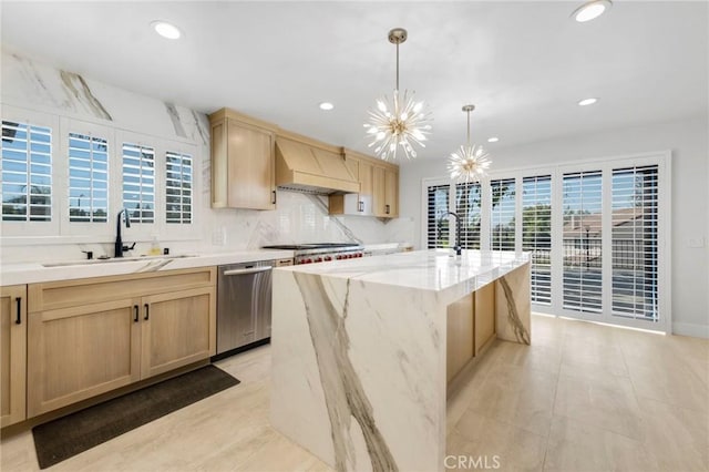 kitchen with light brown cabinetry, sink, a center island with sink, dishwasher, and custom range hood