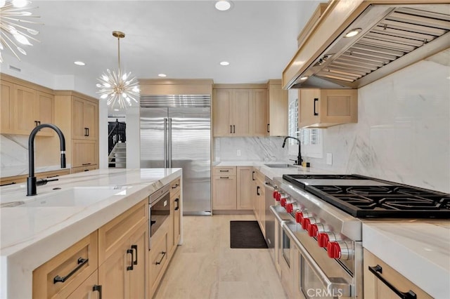 kitchen featuring pendant lighting, sink, built in appliances, custom exhaust hood, and light brown cabinets