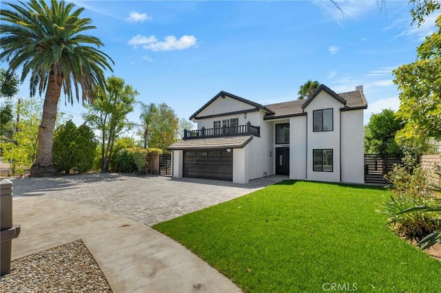 view of front of property featuring a garage, a balcony, and a front lawn