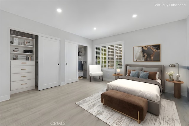 bedroom featuring multiple closets and light hardwood / wood-style flooring