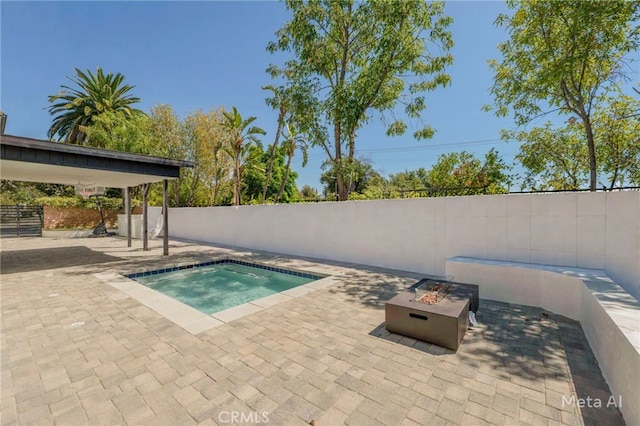 view of swimming pool with a jacuzzi, a patio area, and a fire pit