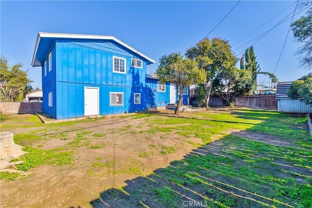 rear view of property featuring a lawn