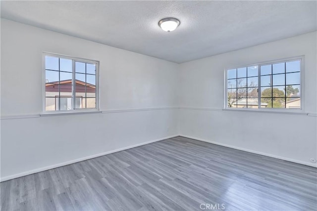 unfurnished room with a textured ceiling and dark hardwood / wood-style flooring