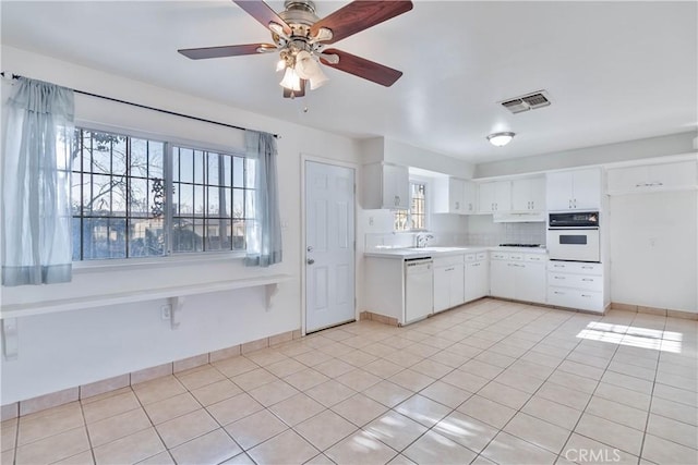 kitchen with ceiling fan, white appliances, light tile patterned flooring, white cabinets, and sink