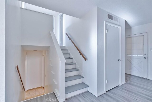 staircase with hardwood / wood-style floors