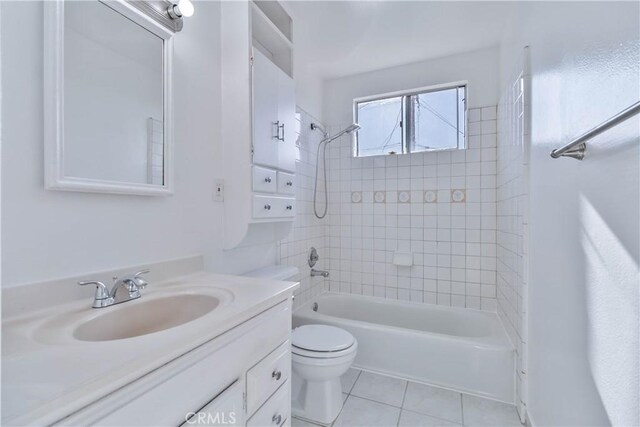 full bathroom featuring toilet, vanity, tiled shower / bath, and tile patterned flooring