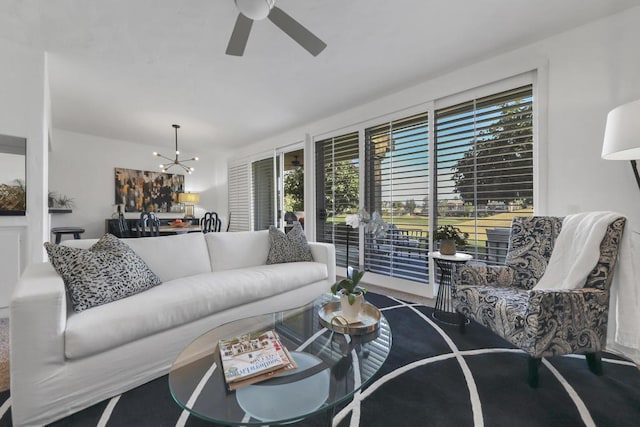 living room featuring ceiling fan with notable chandelier