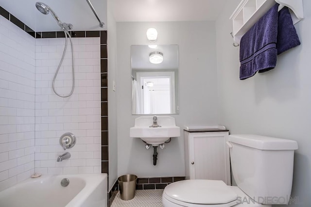 full bathroom with sink, tile patterned floors, tiled shower / bath combo, and toilet