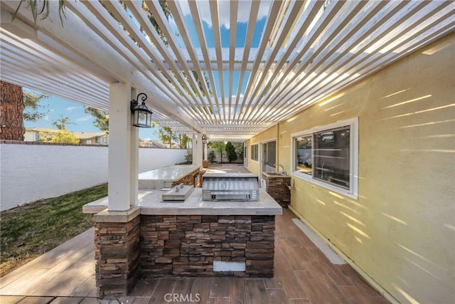 view of patio / terrace with exterior kitchen and a pergola