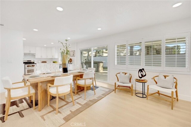 kitchen featuring white cabinetry, stainless steel electric range oven, and light wood-type flooring