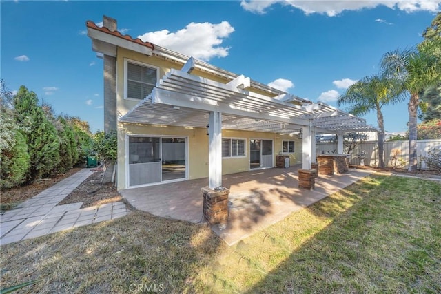 rear view of property with a pergola, a lawn, and a patio