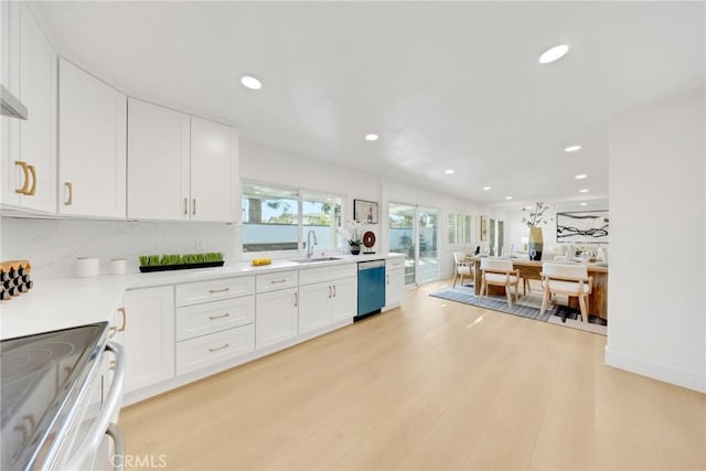 kitchen with white cabinets, range, dishwasher, sink, and light wood-type flooring