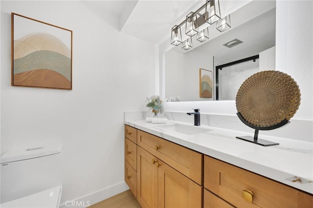 bathroom featuring vanity, wood-type flooring, and toilet