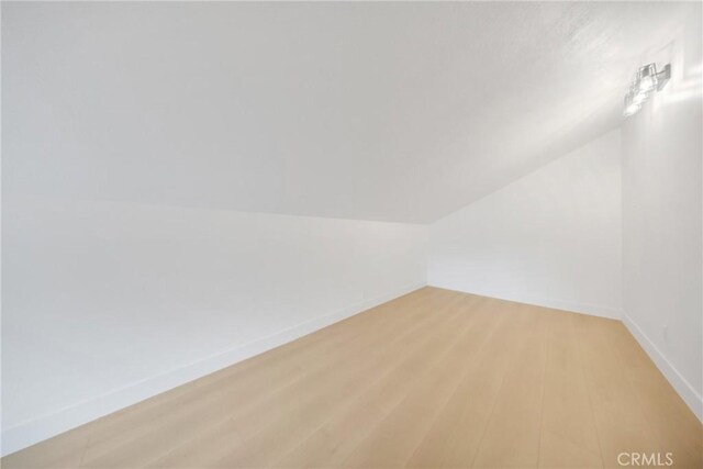 bonus room with light hardwood / wood-style flooring and lofted ceiling