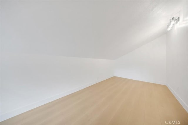 bonus room with lofted ceiling and light hardwood / wood-style floors