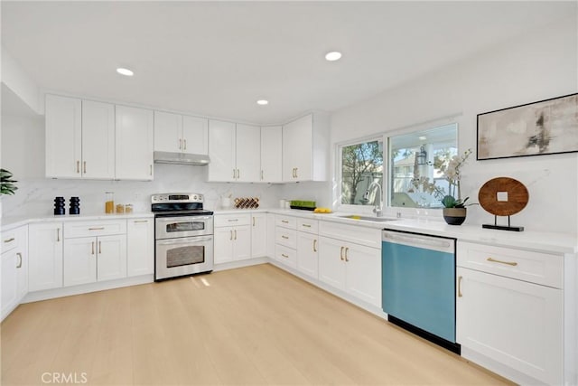 kitchen featuring stainless steel appliances, sink, white cabinets, and light hardwood / wood-style flooring