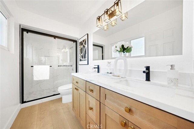 bathroom featuring walk in shower, vanity, toilet, and hardwood / wood-style flooring