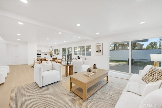 living room with beam ceiling and light hardwood / wood-style floors