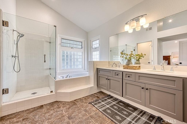 bathroom with vanity, separate shower and tub, and vaulted ceiling