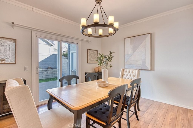 dining space featuring ornamental molding, light hardwood / wood-style flooring, and a notable chandelier