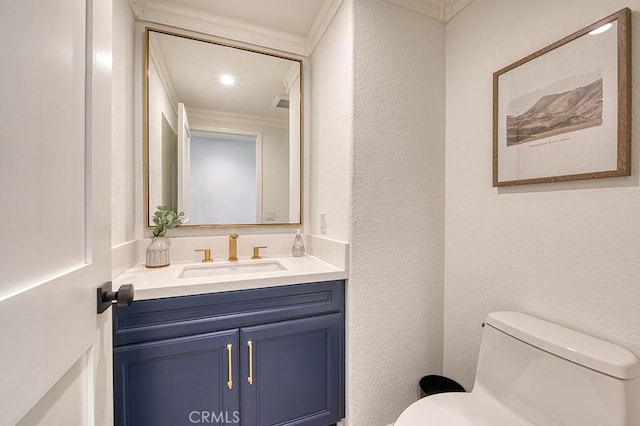 bathroom featuring toilet, vanity, and crown molding