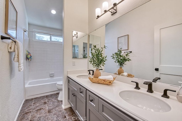 full bathroom featuring toilet, vanity, and  shower combination