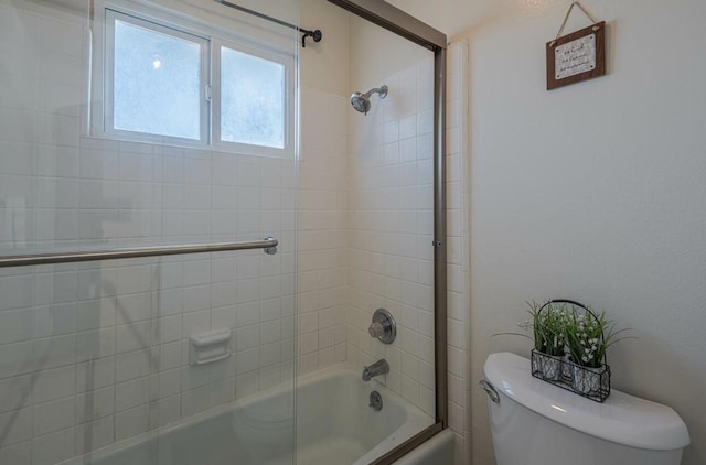 bathroom featuring tiled shower / bath combo and toilet