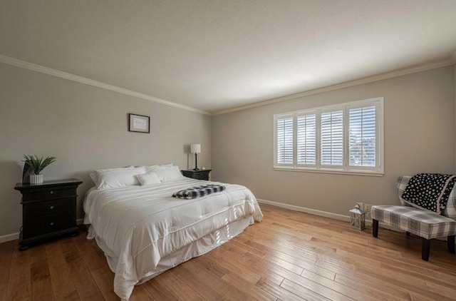 bedroom with ornamental molding and light hardwood / wood-style floors