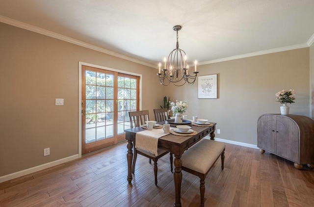 dining room with crown molding, dark hardwood / wood-style floors, and a notable chandelier