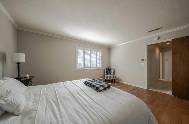 bedroom with ornamental molding and hardwood / wood-style flooring