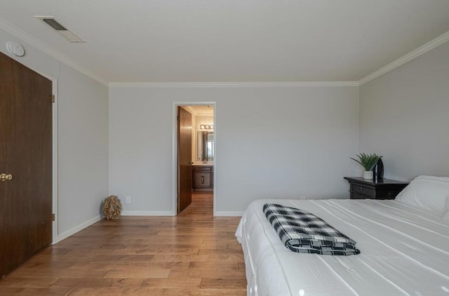 bedroom with ornamental molding, light hardwood / wood-style flooring, and ensuite bath