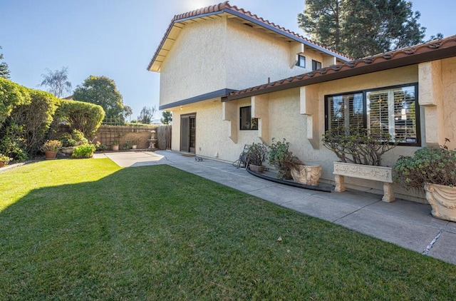 rear view of property with a yard and a patio