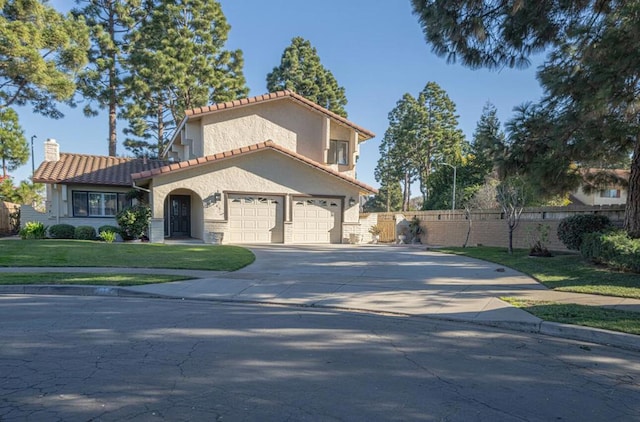 mediterranean / spanish house featuring a garage and a front lawn