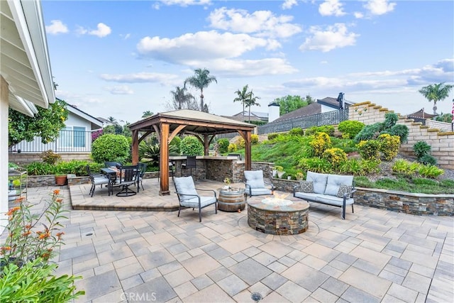 view of patio featuring a gazebo and an outdoor living space with a fire pit