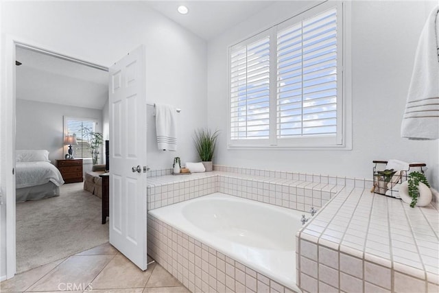 bathroom with tile patterned flooring and tiled tub