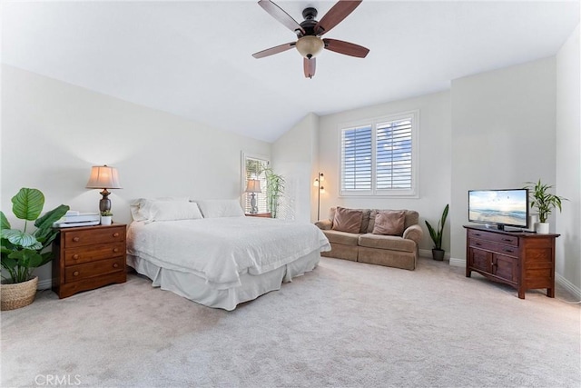 bedroom with ceiling fan, light colored carpet, and vaulted ceiling