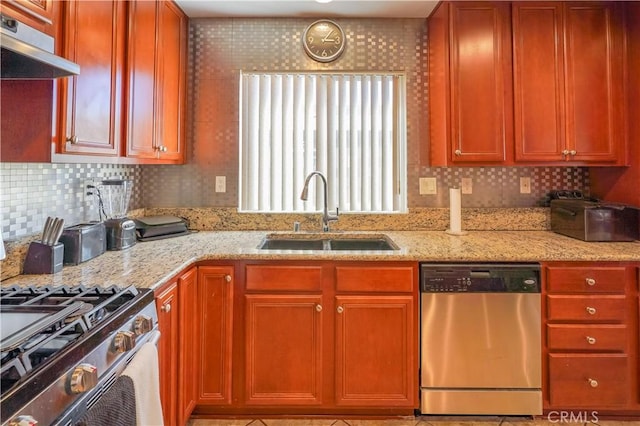 kitchen featuring light stone countertops, stainless steel appliances, backsplash, and sink