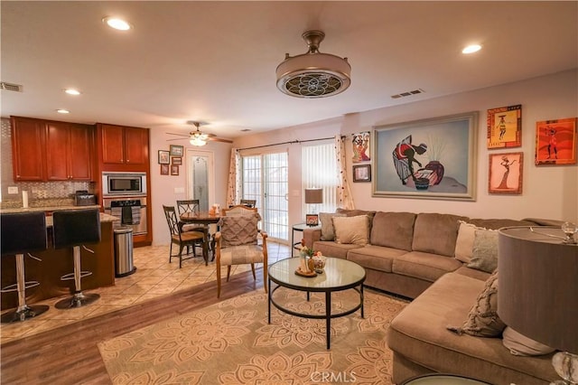 tiled living room with ceiling fan