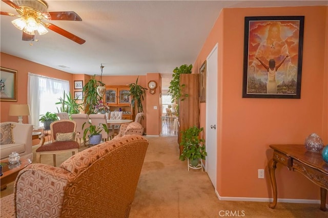 carpeted living room with ceiling fan