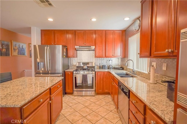 kitchen with light stone counters, sink, appliances with stainless steel finishes, and tasteful backsplash