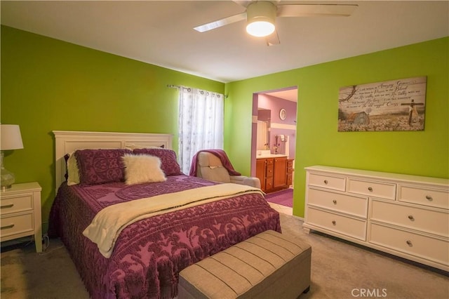 carpeted bedroom with ensuite bathroom and ceiling fan