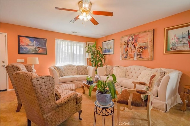 carpeted living room with ceiling fan