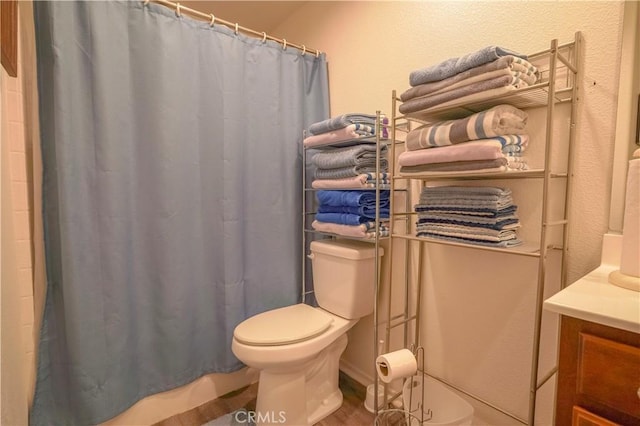 bathroom featuring toilet, walk in shower, hardwood / wood-style flooring, and vanity