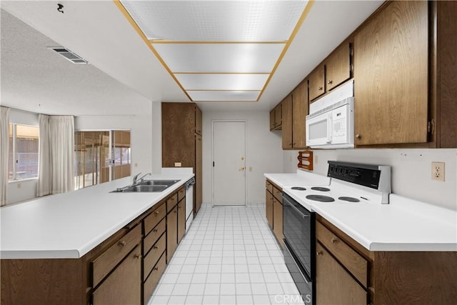 kitchen featuring sink, dishwasher, range with electric stovetop, and kitchen peninsula