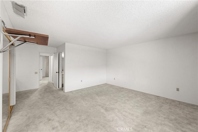 carpeted empty room with a textured ceiling