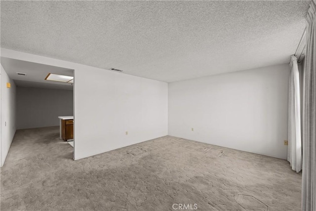 carpeted empty room with a textured ceiling