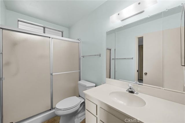 bathroom with an enclosed shower, vanity, and toilet