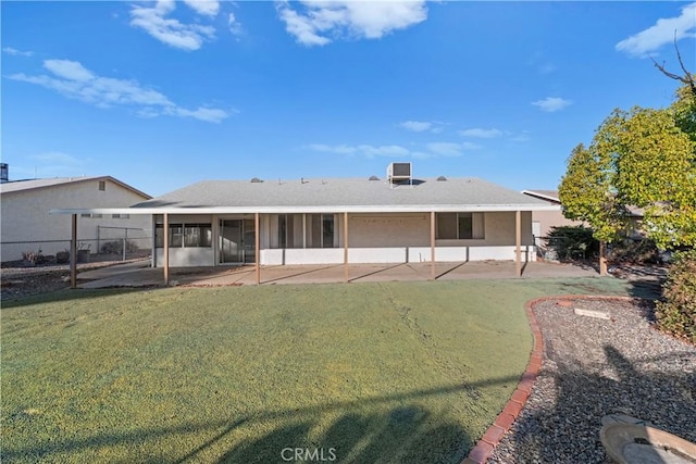 rear view of property featuring a patio area, a yard, and a sunroom