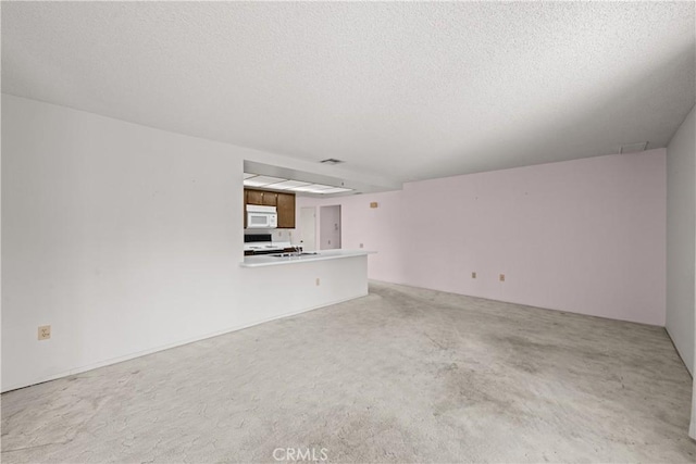 unfurnished living room featuring a textured ceiling and carpet flooring