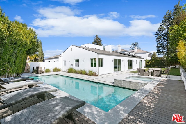 view of swimming pool with an in ground hot tub, a deck, and a patio area